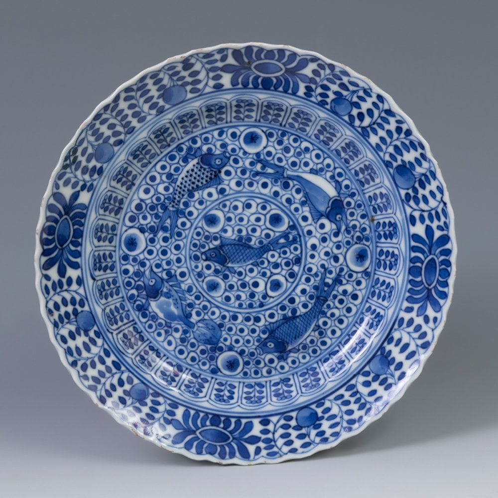 Dish; China, Ming dynasty, 17th century. Porcelain.: Dish; China, Ming dynasty, 17th century. Porcelain. Measurements: 4.6 x 20 cm (diameter). White and blue porcelain dish that stands out for its profuse decoration in which plant, geometric and carp el