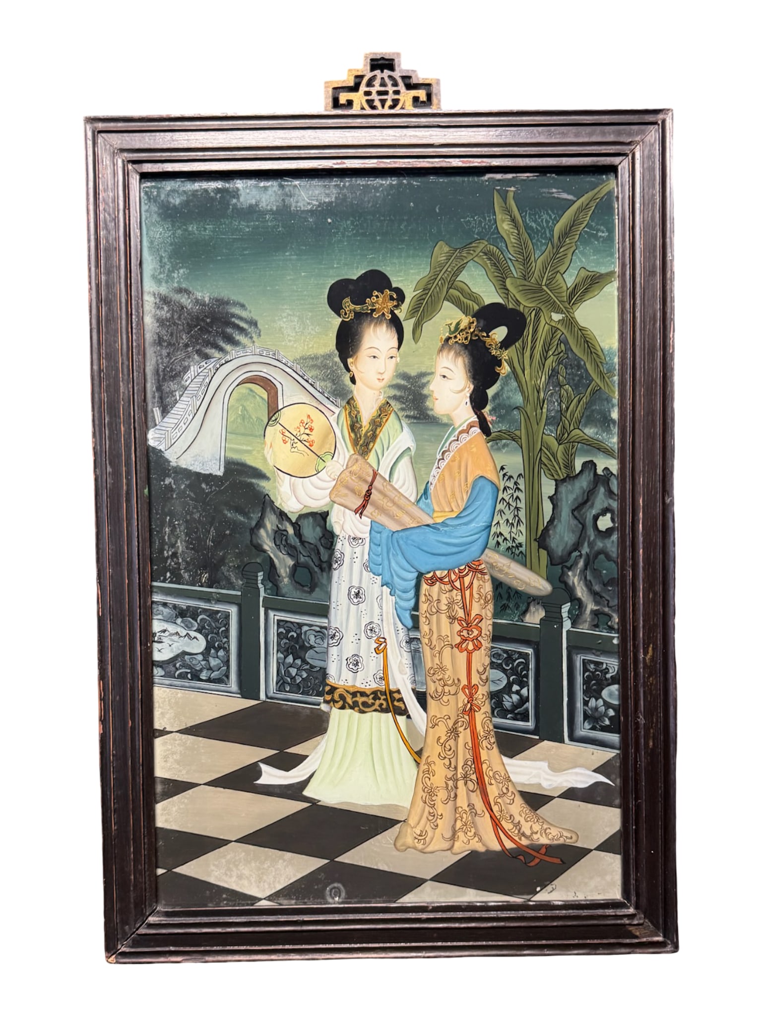 Qing Dynasty Reverse Painting on Glass: This is a Qing Dynasty Chinese reverse painting on glass. It features a pair of Chinese beauties dressed in traditional dress, within a stylized palace garden. This piece is in the original frame, whi