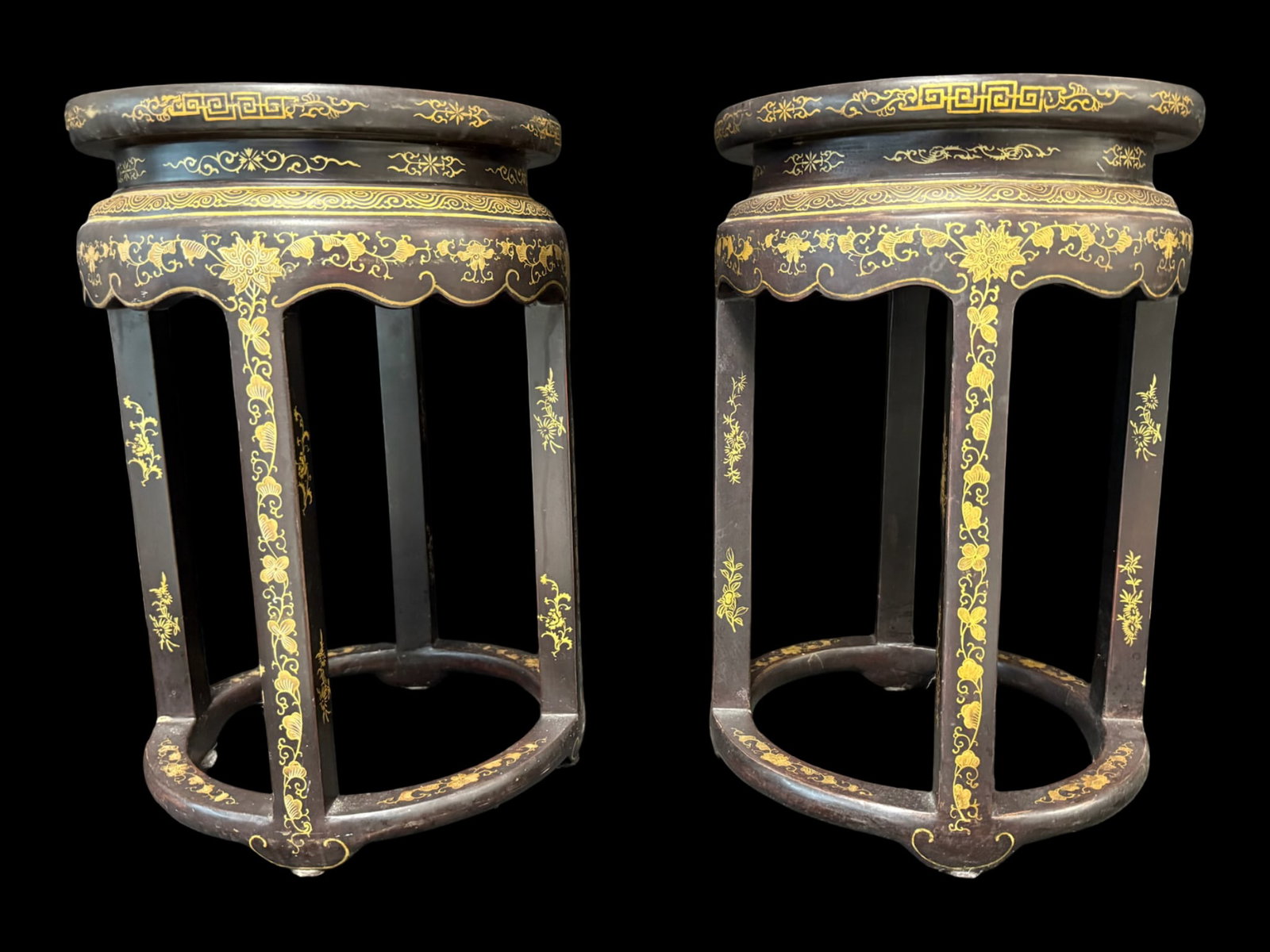 Vintage Chinese Decorated Black Lacquer Side Tables: This matching pair of vintage Chinese black lacquer multi-purpose tables are heavily decorated in the traditional Chinoiserie style, and feature gilt floral and scroll borders, stylized key rims, and 