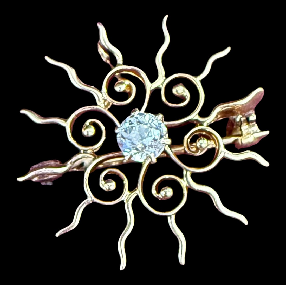 14K Gold Diamond Sunburst Brooch: This antique 14K gold sunburst converter brooch can be worn as a brooch or a pendant. It features an approximately one-quarter carat European-cut center diamond. The wavy rays of the sun radiate out f