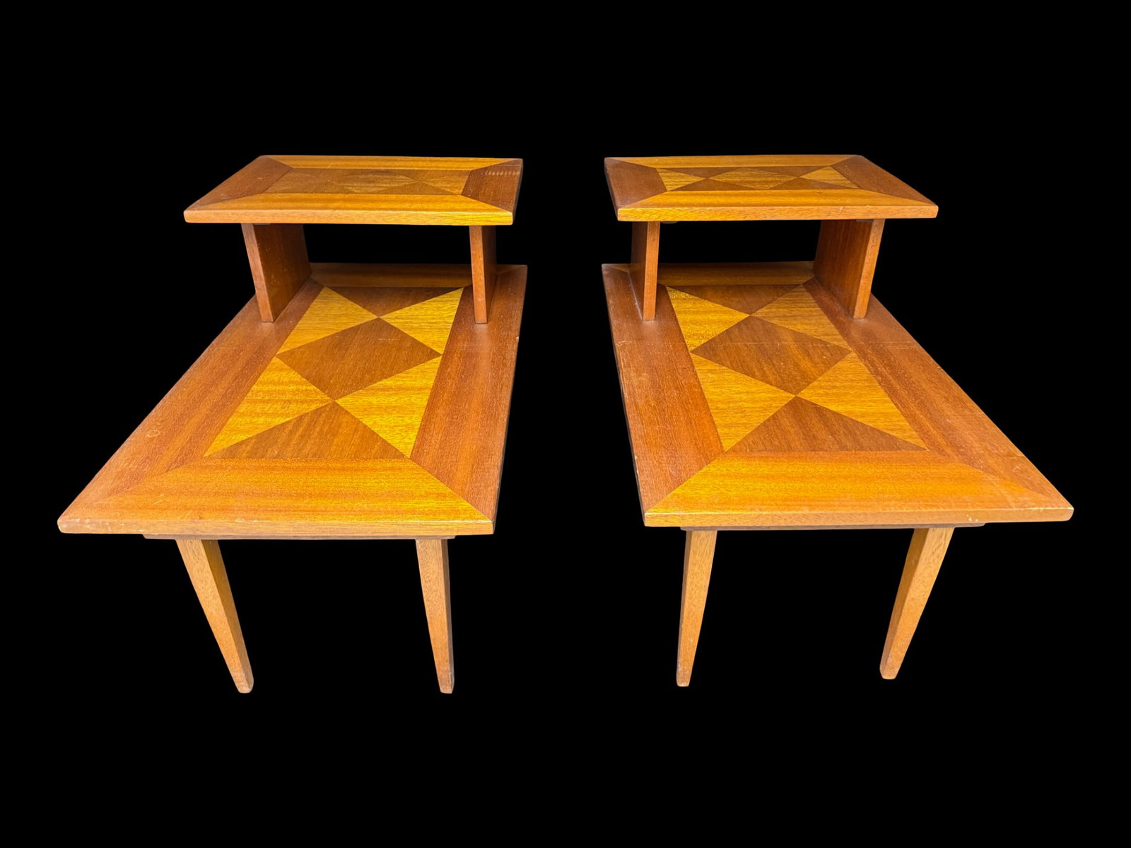 American Mid-Century Two-Tiered Step End Tables: These are most likely made by Lane. They feature an iconic mid-century modern aesthetic with structured geometric diamond parquetry/bookmatched veneer inlay. Total of two tables. Each measures 22.5&rd