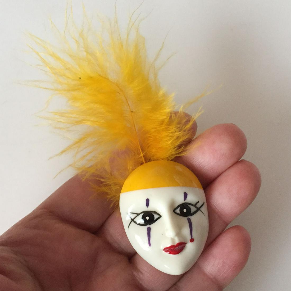 Pierro Clown face brooch with yellow feather: Pierro Clown face brooch with yellow feather. Face measured 1 1/2 x 1 1/4 inches. Condition excellent.