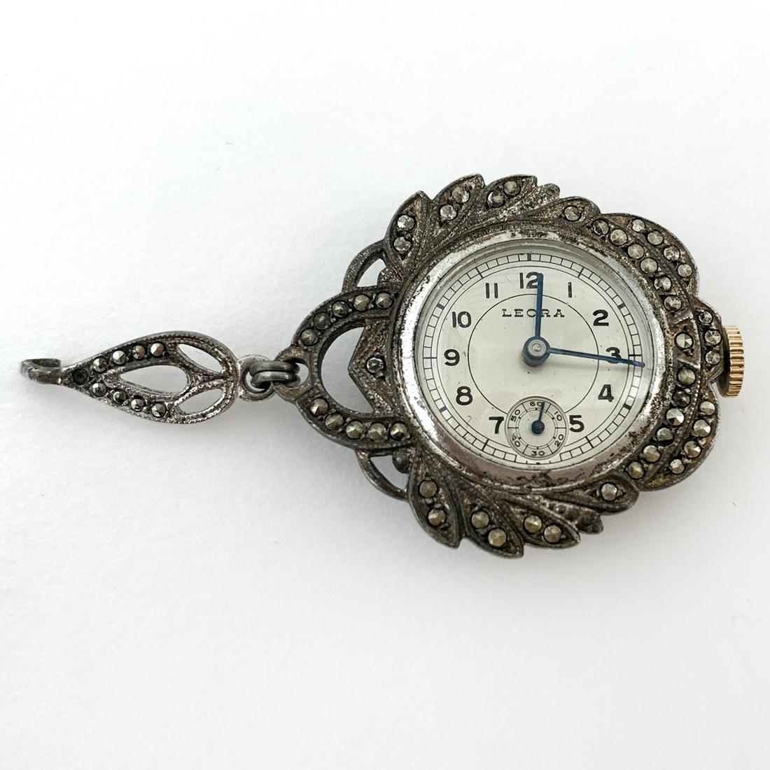 Vintage sterling silver LEORA watch pendant: Vintage sterling silver prongs set marcasites round LEORA Swiss hand wind up movement watch / pendant. Weight 12 grams. Crystal measured 17 mm in diameter. Watch has open loop, can be attached to any 