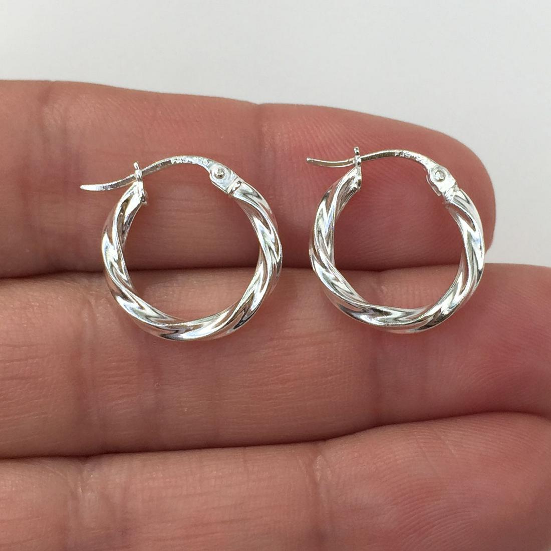 Sterling silver twisted hoop latch back earrings: Sterling silver twisted hoop latch back earrings. Weight 1.32 grams. Hallmarked 925 FAS. Length 5/8 inches. Condition excellent.