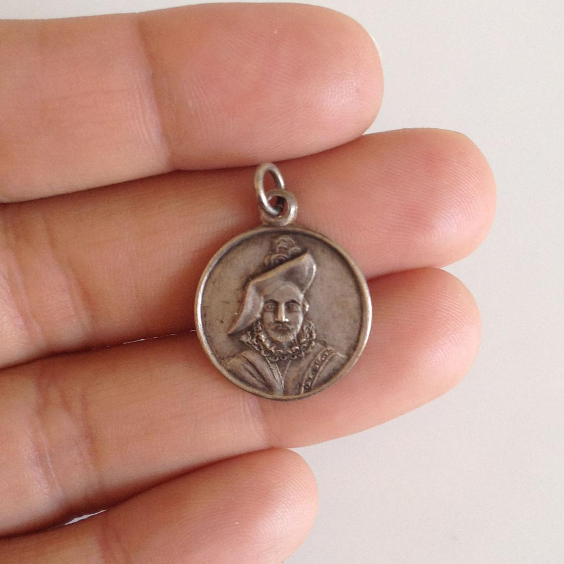 Sterling silver round Shakespeare face pendant charm: Sterling silver round Shakespeare face pendant charm. Weight 2.70 grams. Hallmark Sterling. Length 7/8 inches with bail. Condition excellent.