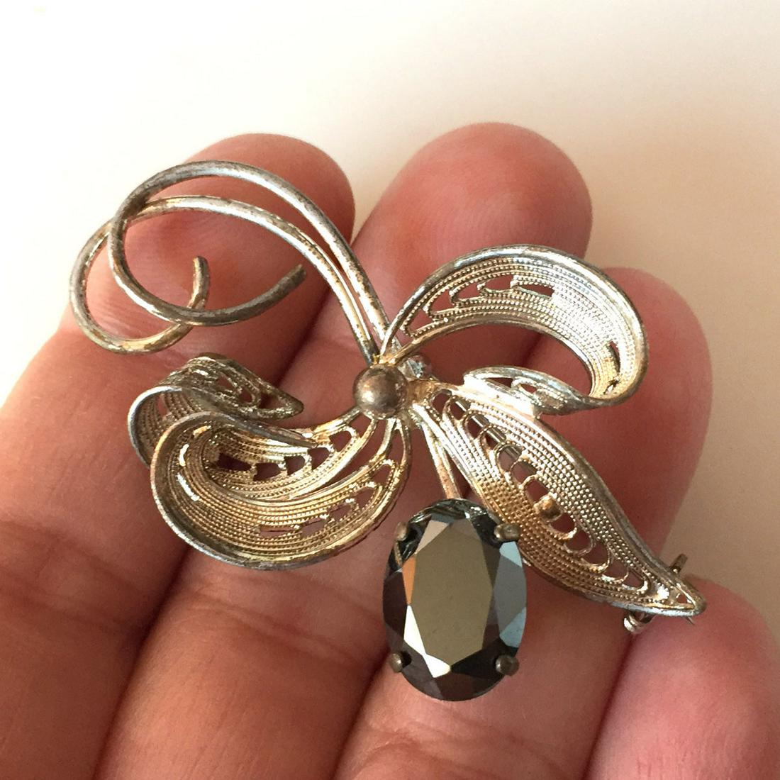 Vintage silver tone Flower shape brooch: Vintage silver tone Flower shape brooch with oval shape faceted hematite. Hallmarked Western Germany. Measured 2 x 1 1/4 inches. Condition good.