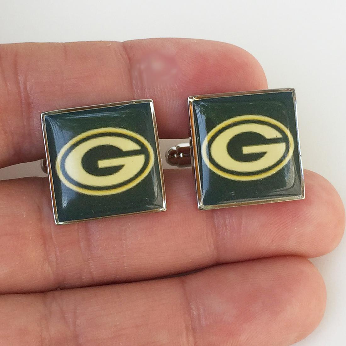 Silver tone NFL Greenbay Packers Football cufflinks: Silver tone NFL Greenbay Packers Football cufflinks. Measured 5/8 x 5/8 inches. Condition very good.