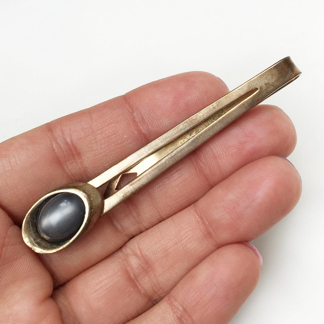 Vintage gold tone gray cat eye color cab bar tie bar: Vintage gold tone gray cat eye color cabochon bar tie bar. Clip length 2 7/8 inches. Condition fair.