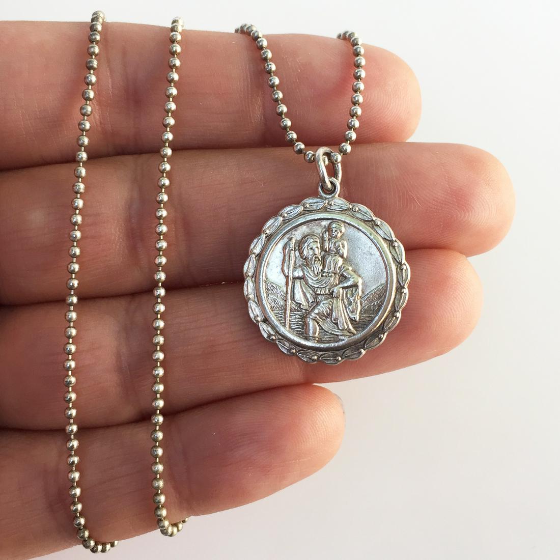Sterling silver Saint Christopher medallion bead chain: Sterling silver Saint Christopher patron of Travelers medallion pendant and bead chain necklace. Weight 8.12 grams. Chain length 30 inches. Medallion pendant length 1 inch with bail. Pendant hallmarke