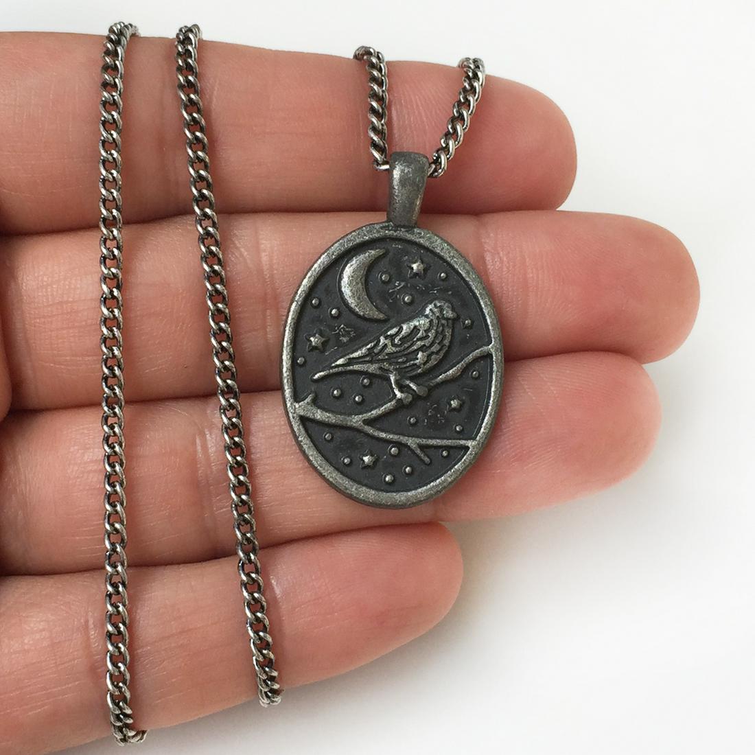 Pewter tone Bird on branch oval pendant chain: Pewter tone Bird on branch oval pendant chain. Pendant length 1 3/8 inches with bail, chain length 18 1/2 inches. Condition very good.