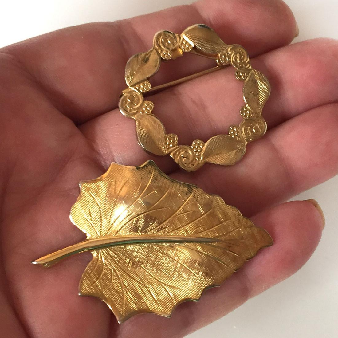 Lot of 2 vintage gold tone Leaf Flower Wreath brooches: Lot of 2 vintage gold tone textured finish Leaf Flower Wreath shape brooches. Leaf brooch measured 2 x 1 1/4 , wreath brooch measured 1 1/4 inches in diameter. Condition excellent.
