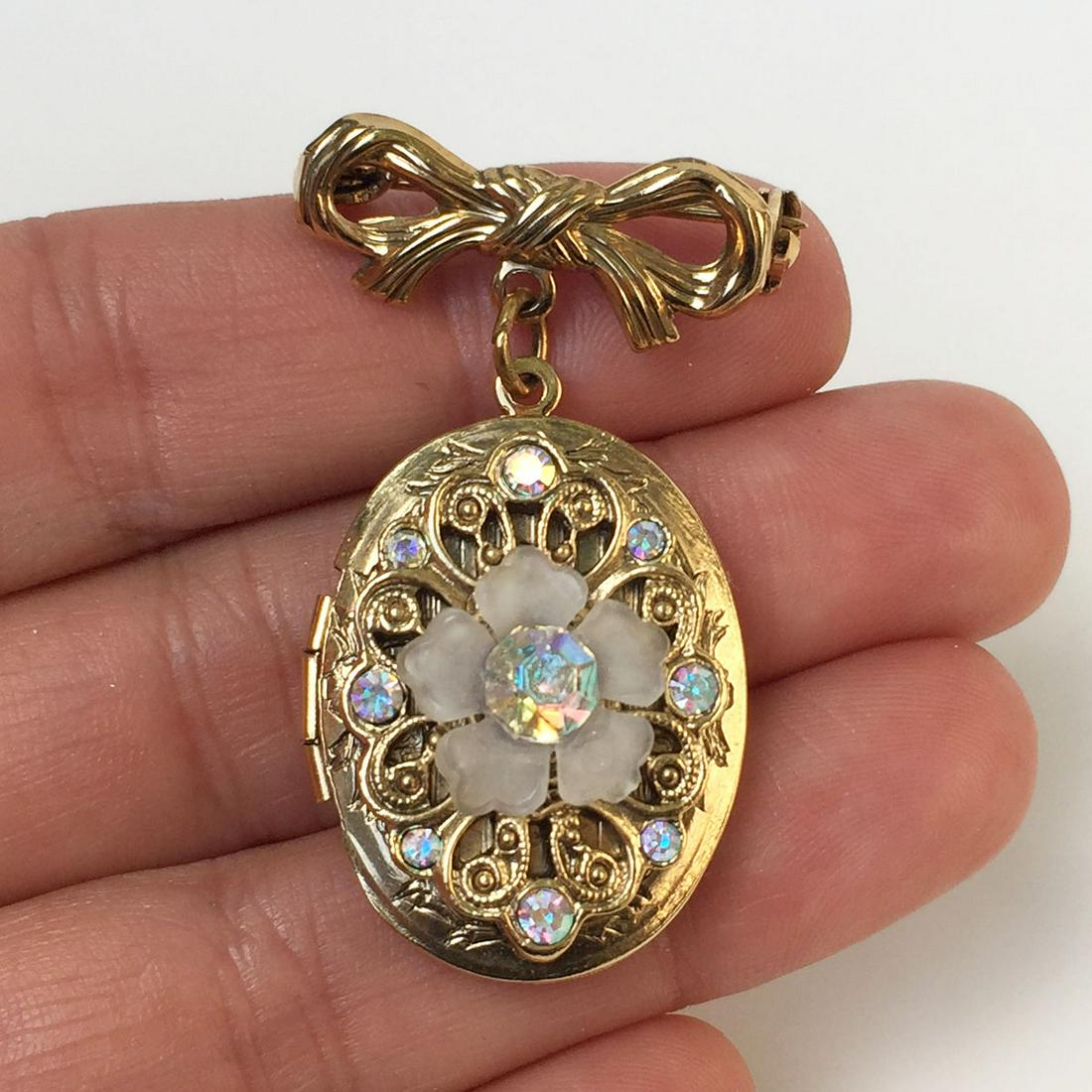 LOREE Gold tone porcelain flower crystals locket brooch: LOREE Vintage gold tone porcelain flower, iridescent crystals dangling locket Bow brooch. Measured 1 5/8 x 1 inches. Condition very good.