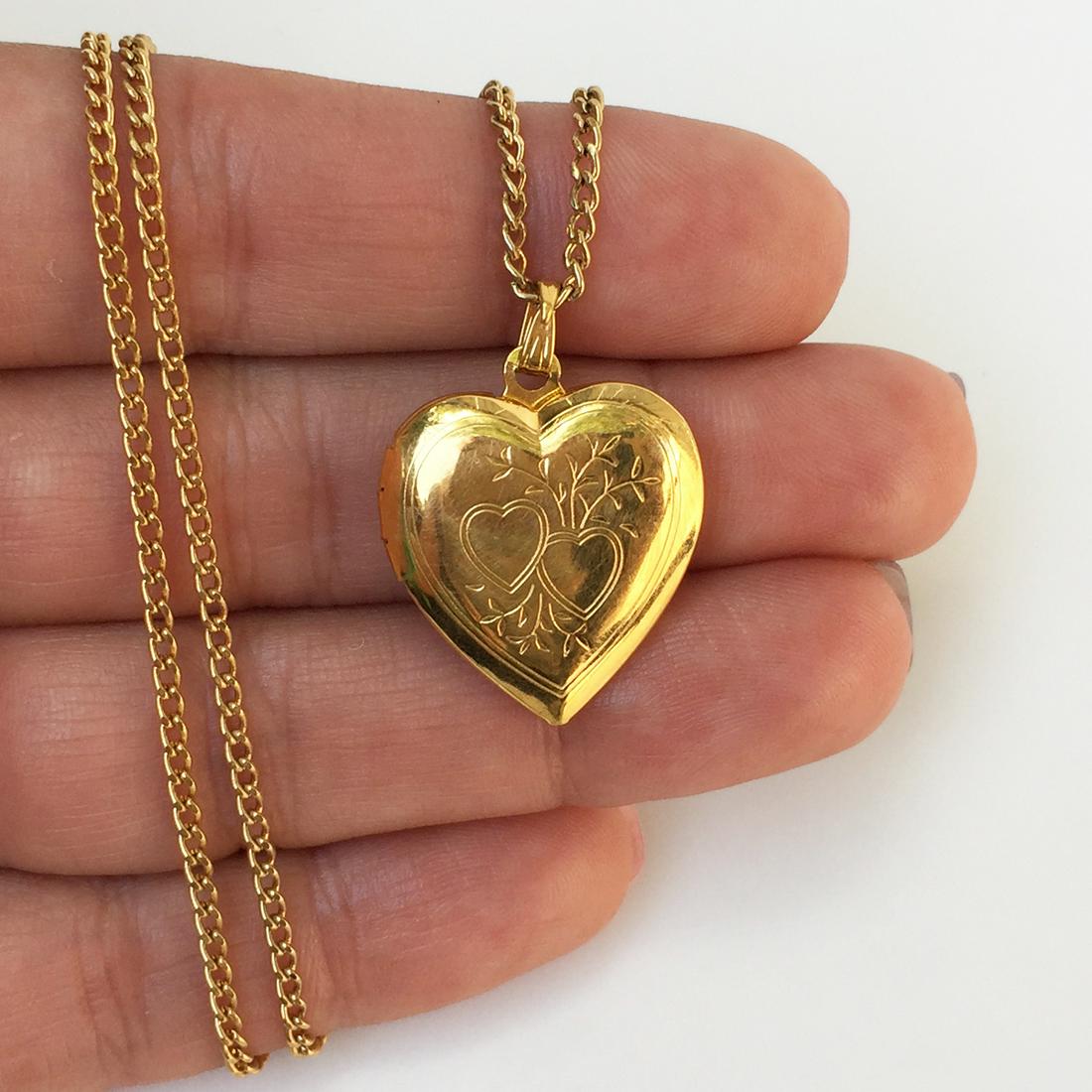 Gold tone Heart shape locket and chain necklace: Gold tone Heart shape locket and chain necklace. Pendant length 1 1/8 inches with bail. Chain length 24 inches. Condition very good.