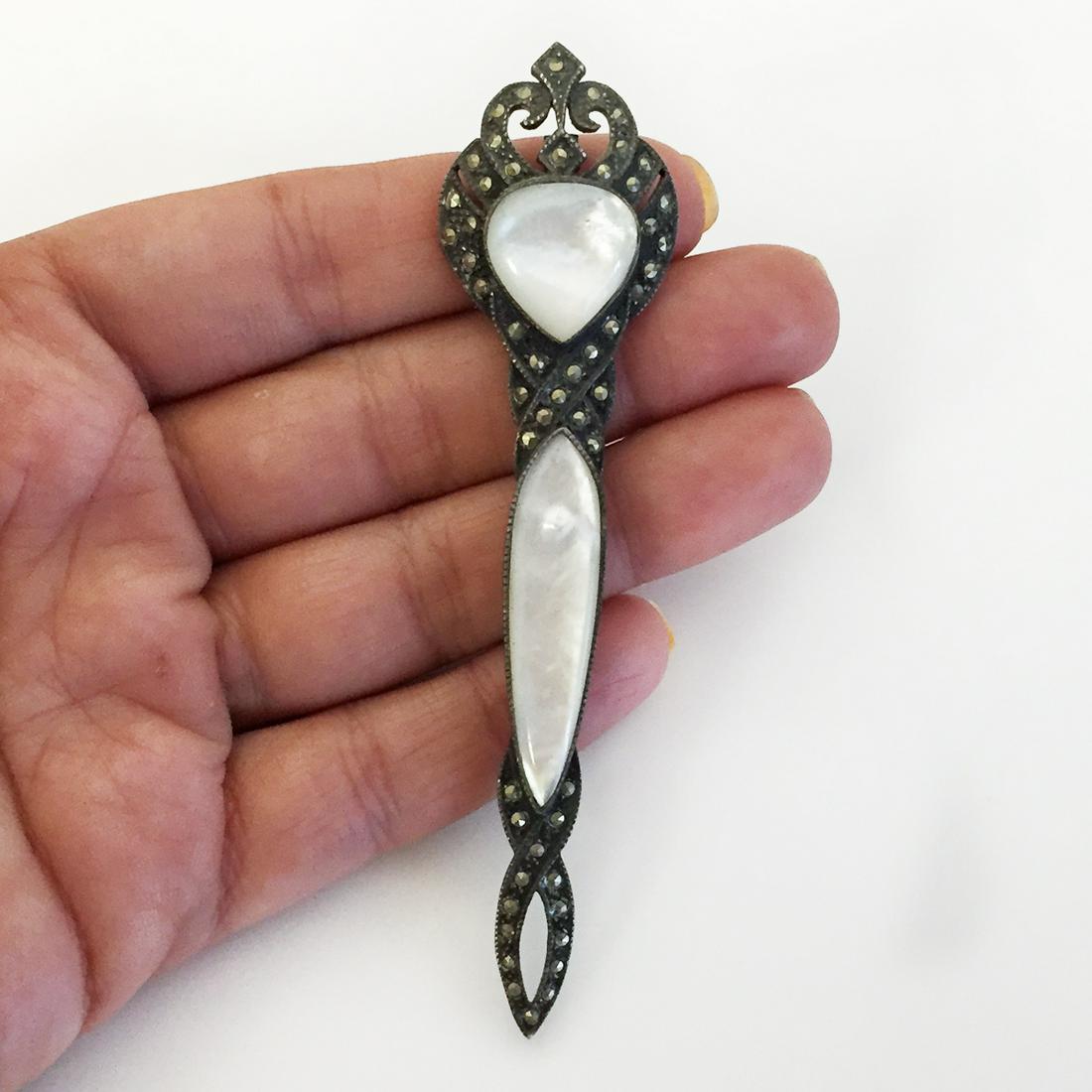 Vintage oxidized sterling silver MOP marcasites brooch: Vintage oxidized sterling silver white mother of pearl marcasites long brooch. Weight 14.42 grams. Measured 3 7/8x 1 inches. Hallmarked 925. Condition very good.