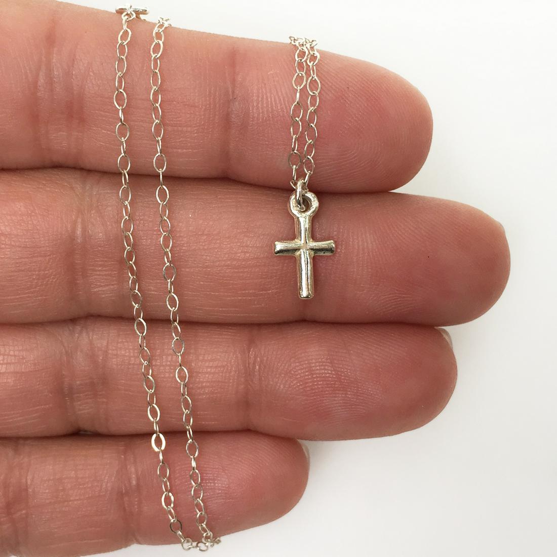 Sterling silver tiny cross pendant and chain necklace: Sterling silver tiny cross pendant and chain necklace. Weight 1.28 grams. Hallmarked 925. Pendant length 1/2 inches with bail. Chain length 14 inches + 1 inch extension. Condition very good.