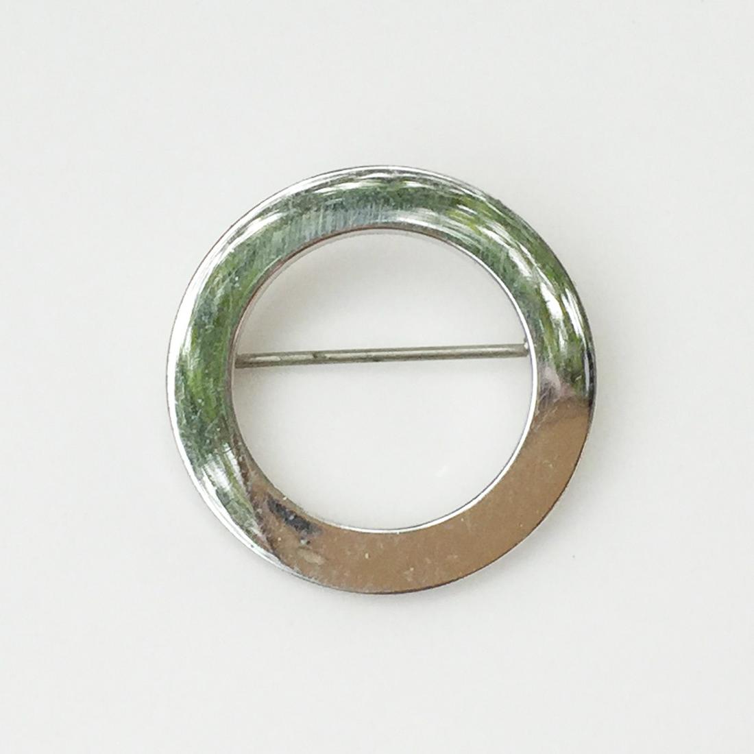 MONET Silver tone circle brooch, signed: MONET Silver tone circle brooch, signed. Measured 1 1/8 inches in diameter. Hallmarked ©Monet. Condition very good.
