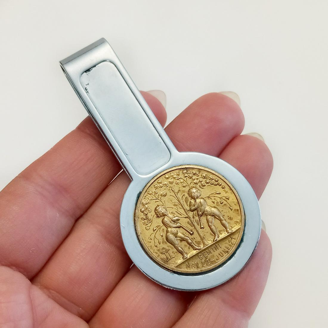 Silver tone gold tone GEMENI Good Luck money clip: Silver tone gold tone textured finish GEMENI medallion, signed Good Luck money clip. Measured 2 5/8 x 1 7/8 inches. Condition good.