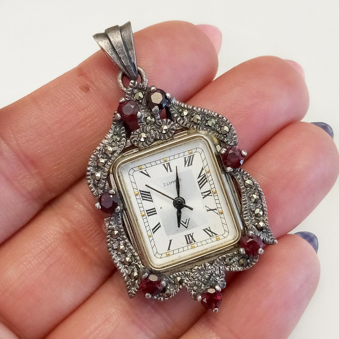 Sterling silver marcasites garnet Watch pendant: Sterling silver marcasites, faceted garnet Watch pendant. Weight 17.48 grams. Length 2 inches with bail. Watch case is metal, design around and bail is sterling silver and hallmarked 925, <<. Watch ca