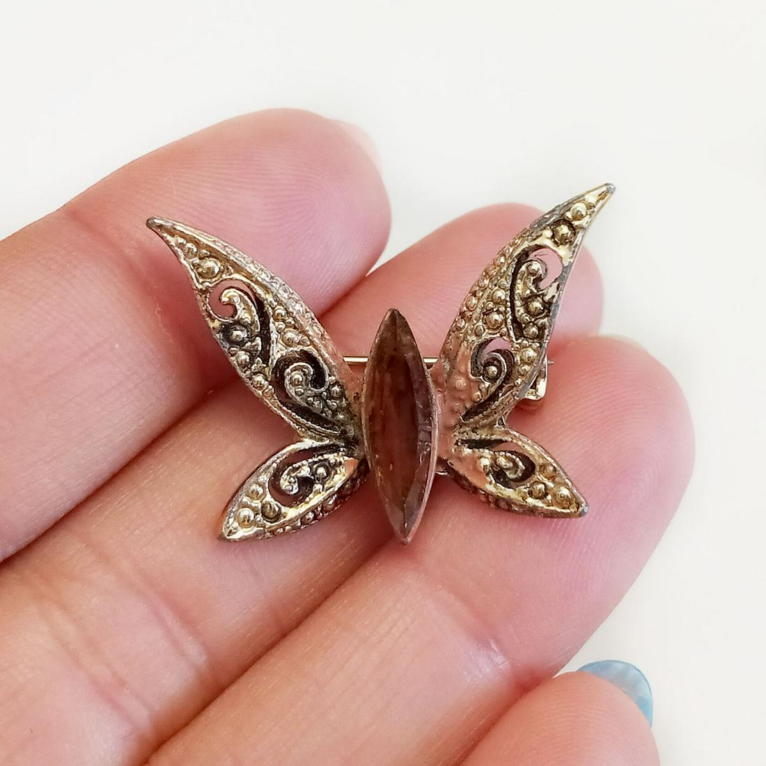 Gold tone beryl color rhinestones Butterfly brooch: Gold tone textured finish, marquise shape beryl color rhinestones Butterfly brooch. Measured 1 1/4 x 7/8 inches. Condition very good.