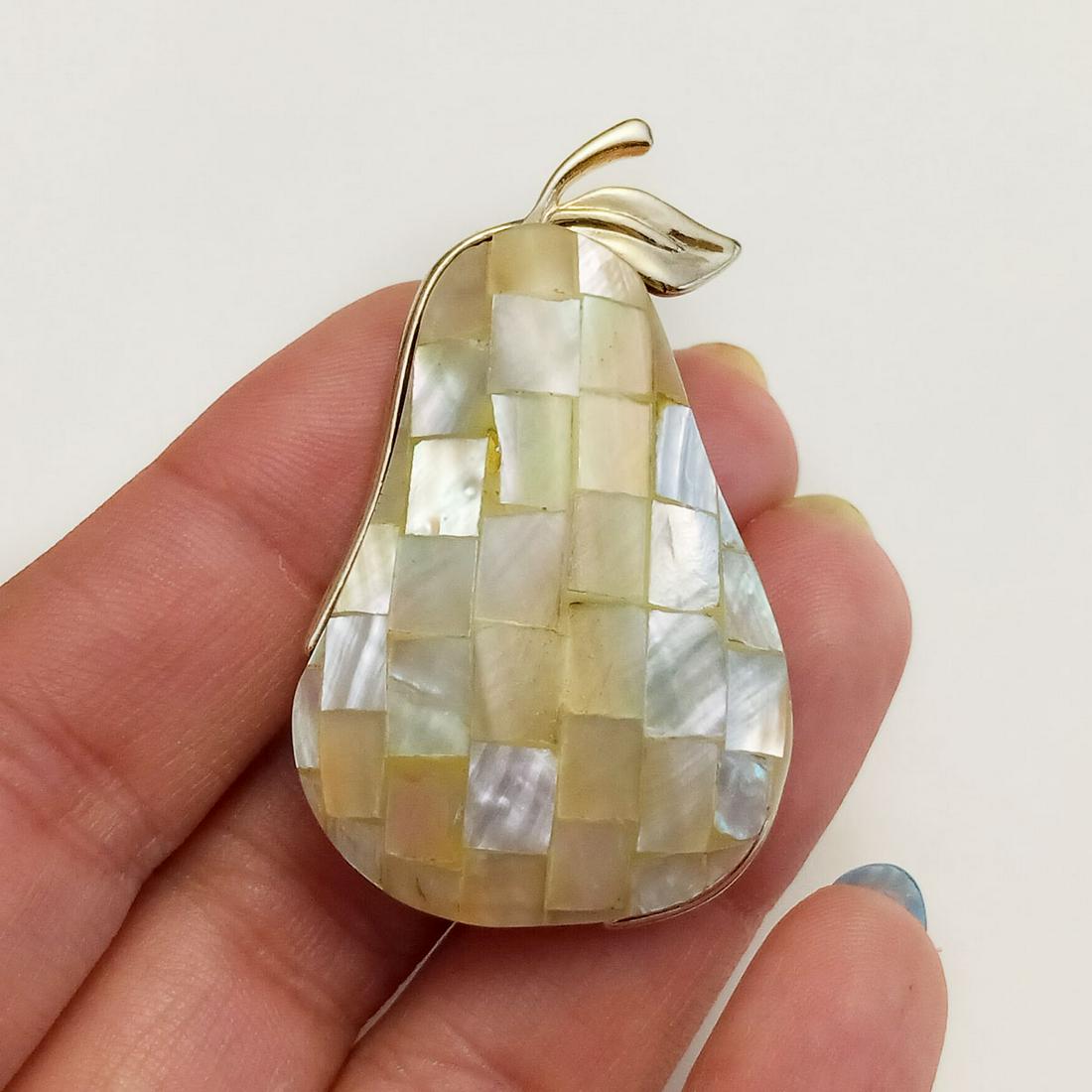 LIZ CLAIBORNE Vintage gold tone MOP Pear brooch, signed: LIZ CLAIBORNE Vintage gold tone Mother of Pearl tiles Pear shape brooch, signed. Measured 1 7/8 x 1 1/8 inches. Hallmarked LC. Condition very good.