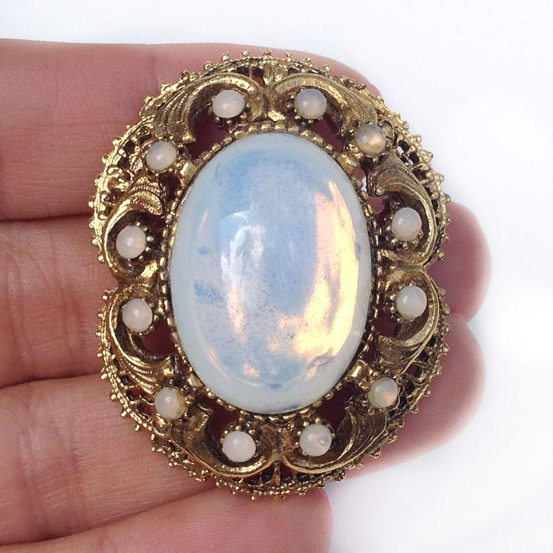 Vintage gold tone oval moonstone color cabochons brooch: Vintage gold tone oval moonstone color cabochons brooch. Measured 1 3/4 x 1 3/8 inches. Condition excellent.