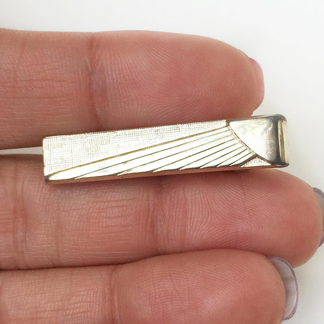 FOSTER Vintage gold tone textured finish tie clip: FOSTER Vintage gold tone textured finish tie clip, signed. Hallmarked Foster, made in USA. Length 1 3/8 inches. Condition very good.