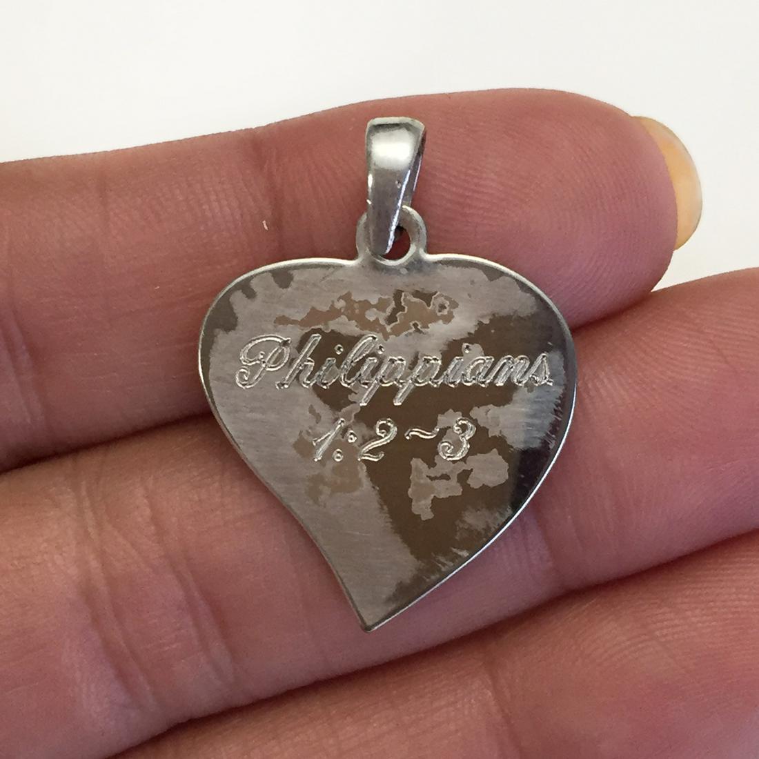 Silver tone engraved Philippians 1:20-3 heart pendant: Silver tone engraved Philippians 1:20-3 heart pendant. Length 1 1/8 inches with bail. Condition fair.