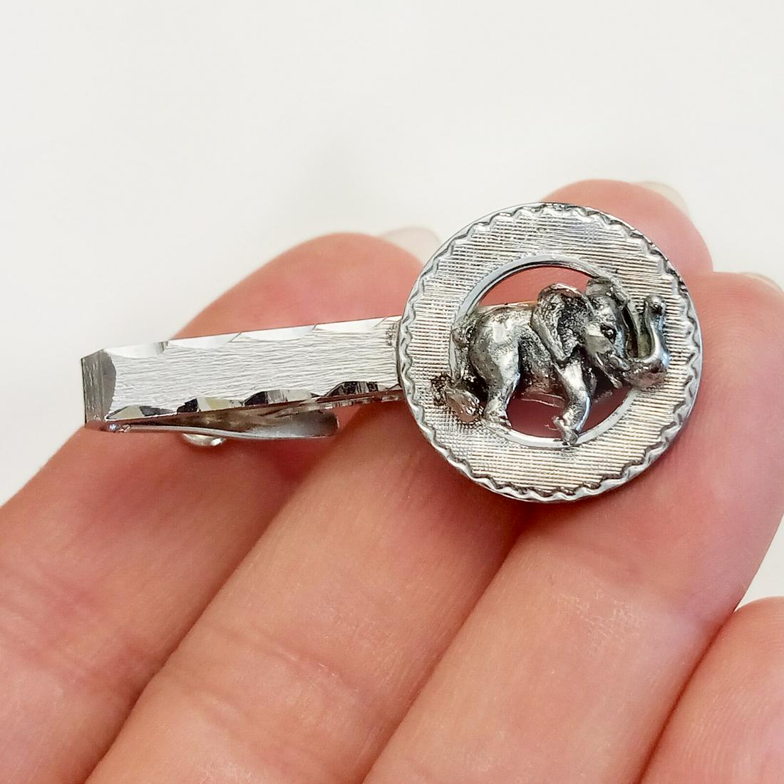 FOSTER Silver tone, silver Elephant tie clip, signed: FOSTER Silver tone textured finish and sterling silver Elephant tie clip, signed. Measured 1 5/8 x 3/4 inches. Elephant is sterling silver, the rest of the clip is silver tone. Hallmarked Foster, Made