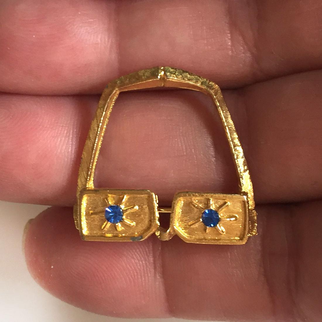 Vintage gold tone Forehead and Glasses "geek" brooch: Vintage gold tone textured finish Forehead and Glasses "geek" brooch with blue crystals. Measured 1 x 1 inches. Condition very good.