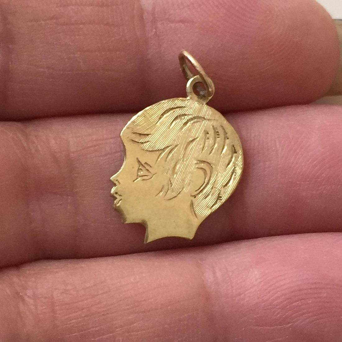 10K yellow gold Boys face profile pendant charm: 10K yellow gold textured finish Boys face profile pendant charm. Weight 1.34 grams. Length 1 inch with bail. No hallmark, tested 10K gold. Condition very good.