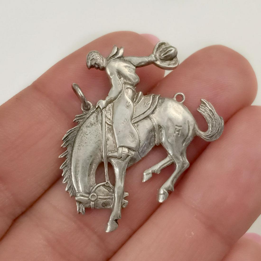 Vintage sterling silver Rodeo Cowboy Horse charm: Vintage sterling silver Rodeo Cowboy Horse shape pendant charm. Weight 5.34 grams. Measured 1 1/4 x 1 1/8 inches with bail. No hallmark, tested 925. Condition very good.