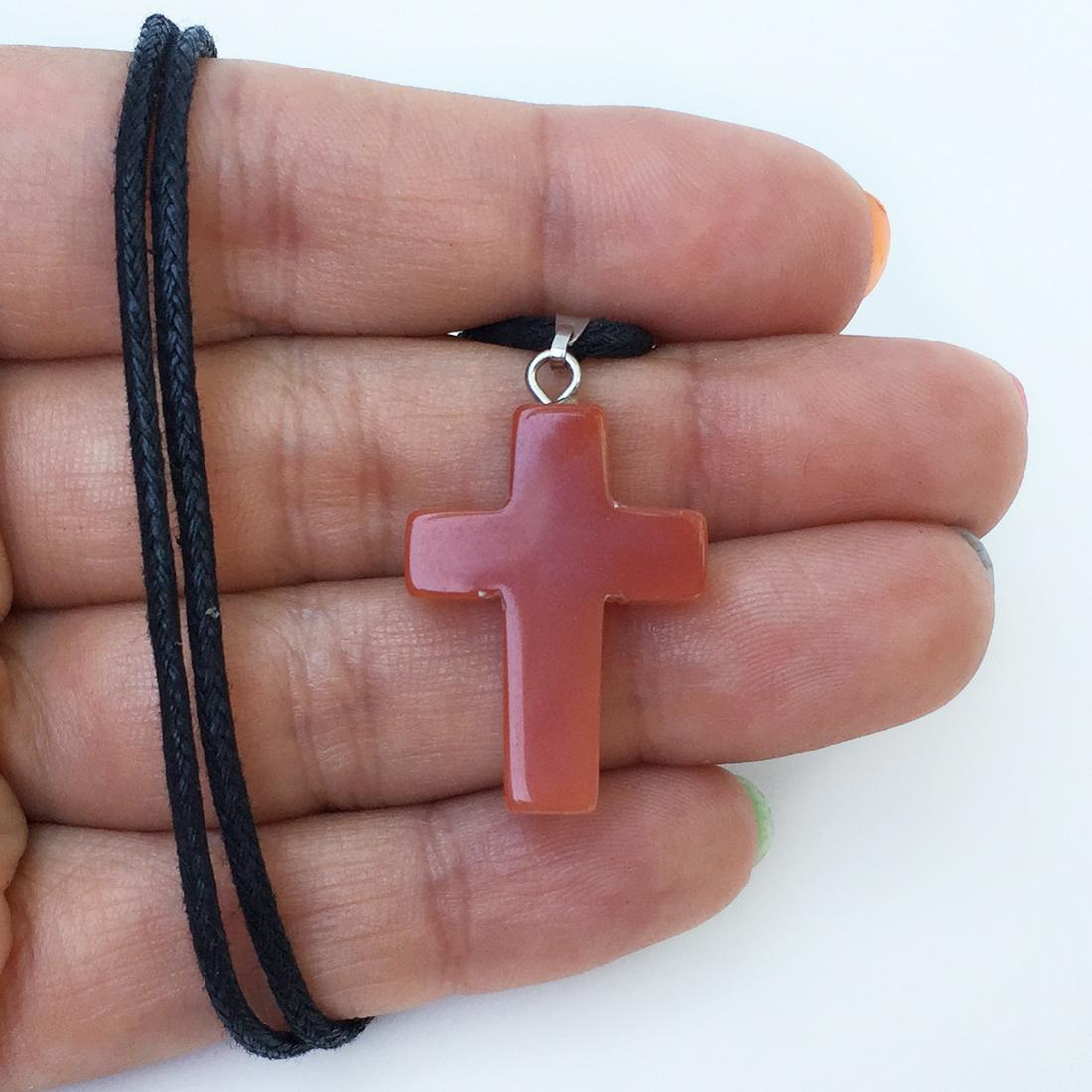 Red carnelian color Cross pendant black cord necklace: Red carnelian color Cross pendant black cord necklace. Pendant length 1 1/4 inches with bail, cord length 16 inches + 2 inches extender. Condition very good.