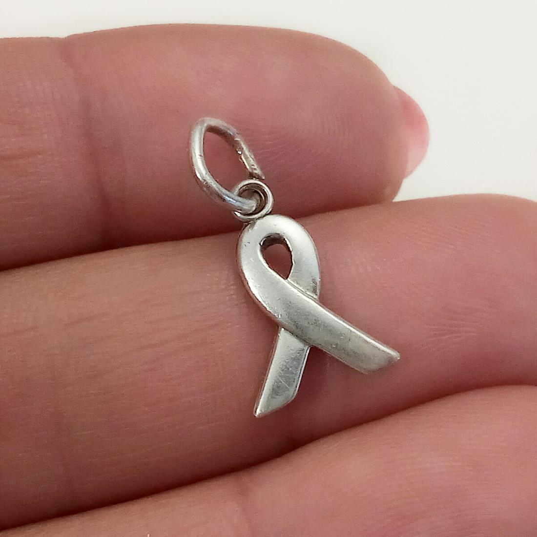 Sterling silver Breast Cancer Ribbon charm pendant: Sterling silver Breast Cancer Ribbon charm pendant. Weight 0.70 grams. Length 3/4 inches with bail. Hallmarked Breast Cancer .925, logo in a sun symbol. Condition very good.