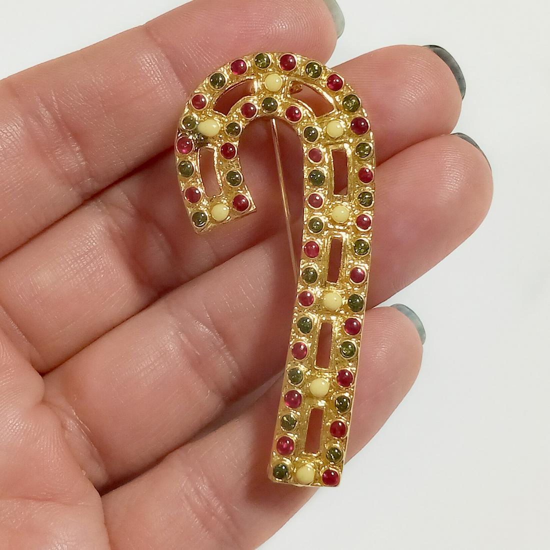 Vintage gold tone enamel candy cane brooch: Vintage gold tone red, green and white enamel candy cane brooch. Measured 2 x 1 inches. Condition very good.
