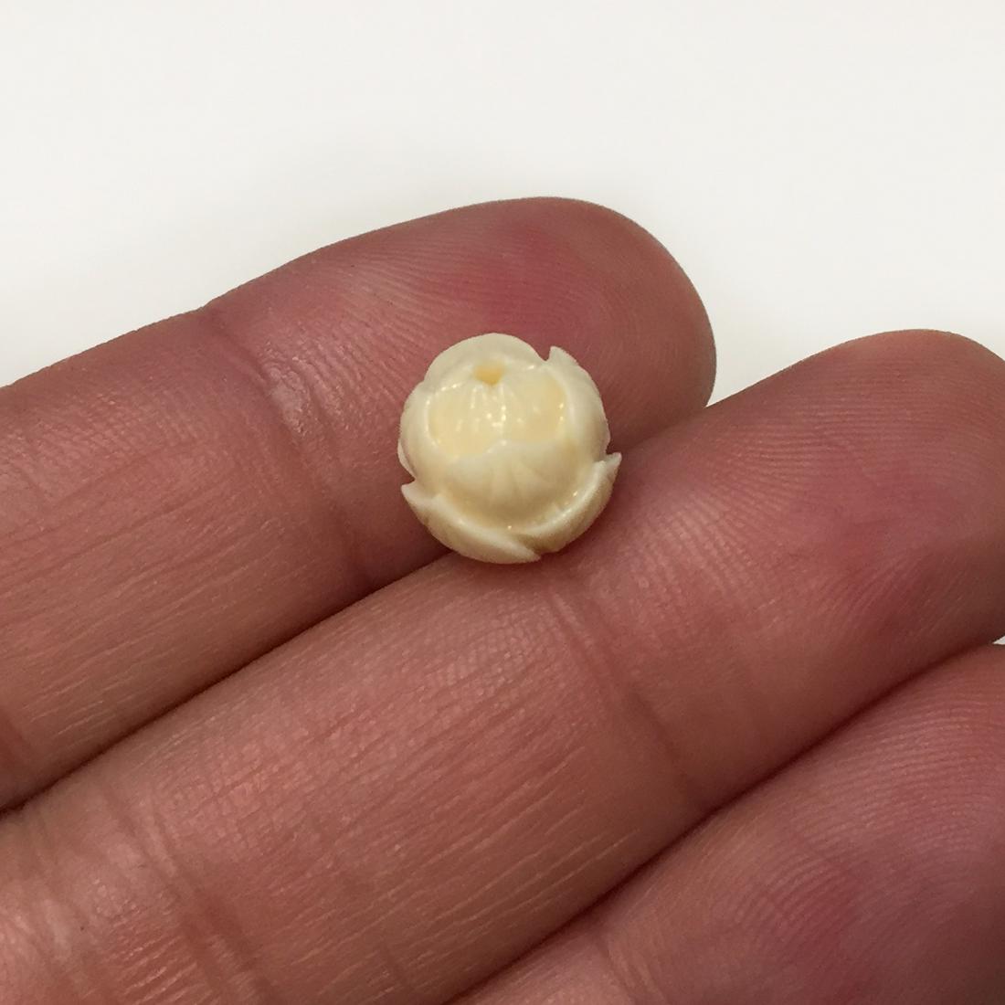 Carved off-white synthetic coral Flower drilled bead: Carved antique color, off-white, ivory color synthetic coral round Lotus Flower drilled through 9 mm bead. Bead measured 9.4 mm in diameter. Beads are made out of resin and powder coral.