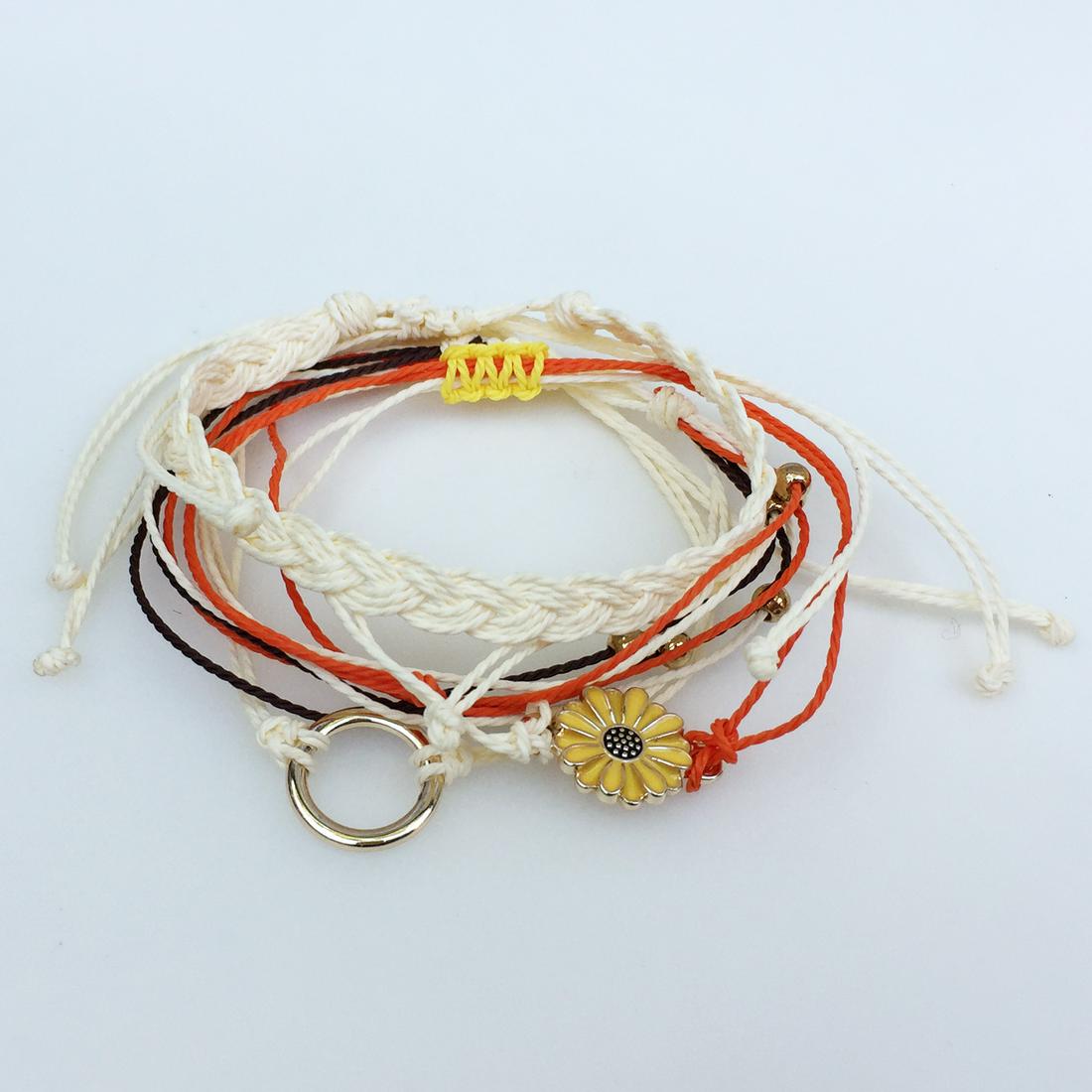 set of 4 ivory orange braided woven string bracelets: set of 4 ivory orange braided woven string bracelets. Bracelets are adjustable. Bracelet has yellow daisy flower. Condition excellent.