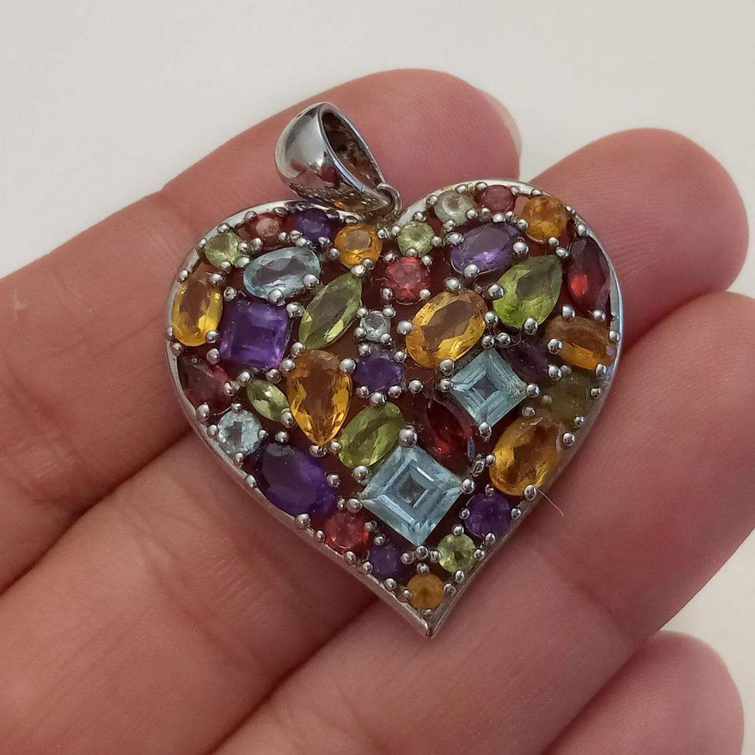 Sterling silver multicolor genuine stone heart pendant: Sterling silver faceted genuine garnet, amethyst, peridot, topaz, citrine heart shape pendant. Weight 8.12 grams. Length 1 1/2 inches with bail. Hallmarked EA, 925, China. Condition very good.