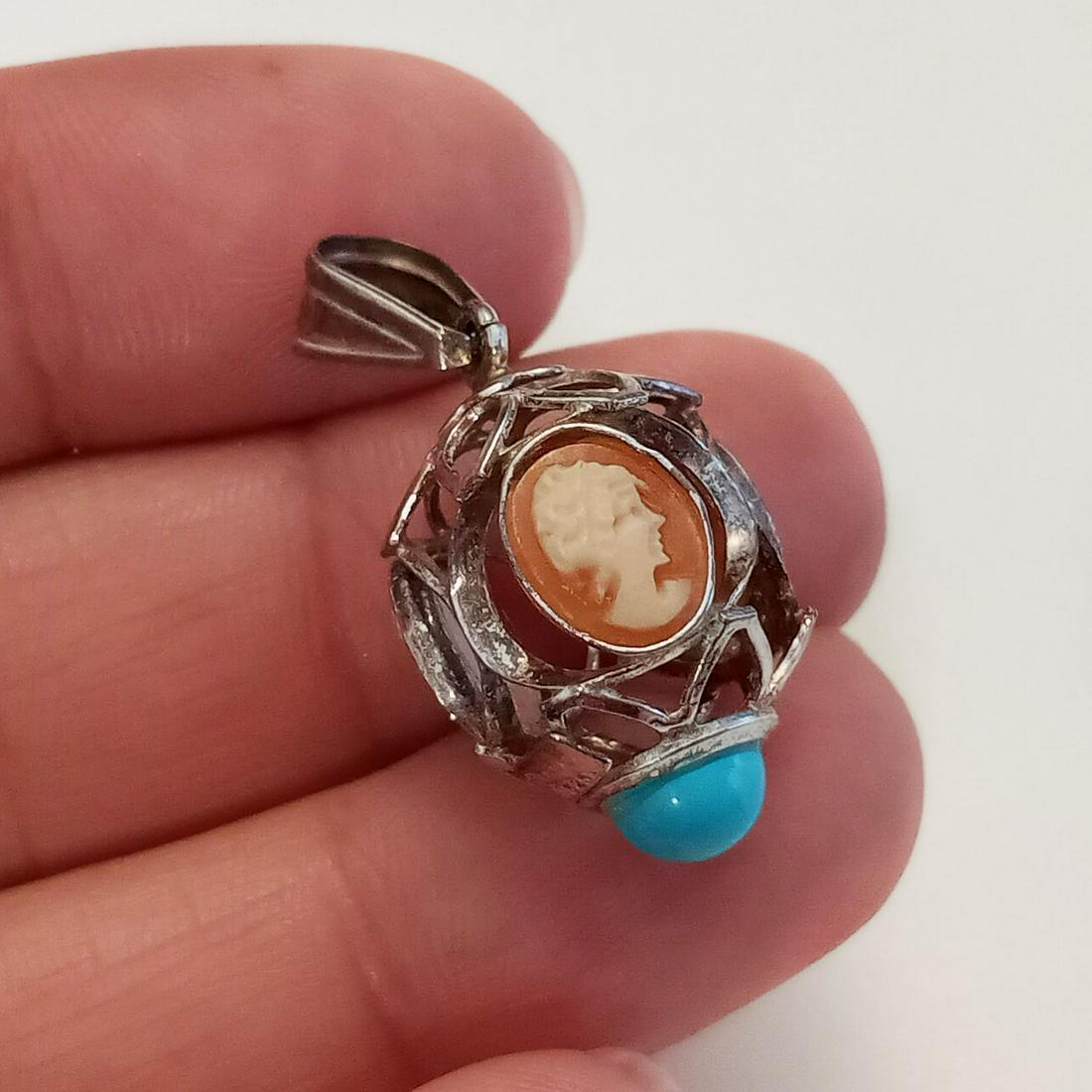 Sterling silver 3 cameos, blue cab egg shape 3D pendant: Sterling silver 3 acrylic cameos, blue turquoise color cabochon, egg cage shape 3D pendant. Weight 2.49 grams. Length 1 1/8 inches with bail. Hallmarked 925, star symbol 781, MA. Condition very good.