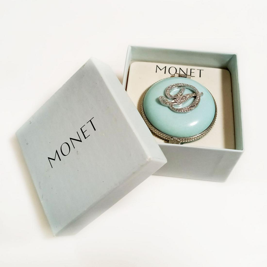 MONET silver tone blue ceramic letter D trinket box: MONET silver tone clear rhinestones blue ceramic letter initial D round shape jewelry trinket box. Measured 2 1/8 inches in diameter x 1 inch in height. Comes in an original box. Condition very good.
