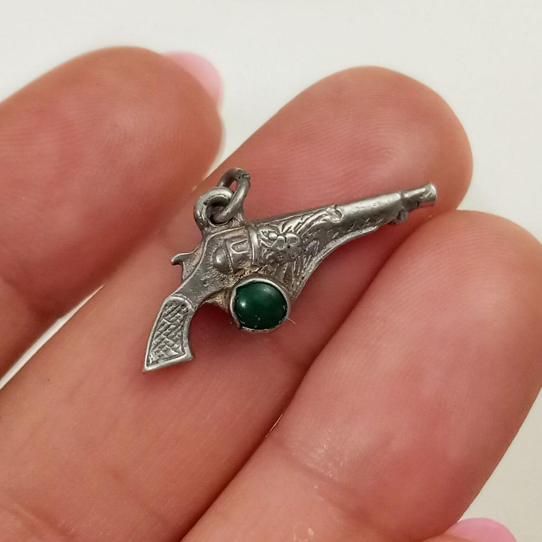 Vintage sterling silver green cab Revolver Gun charm: Vintage sterling silver green cabochon Revolver Gun shape charm. Weight 1.81 grams. Measured 1/2 x 7/8 inches with bail. No hallmark, tested 925. Condition very good.