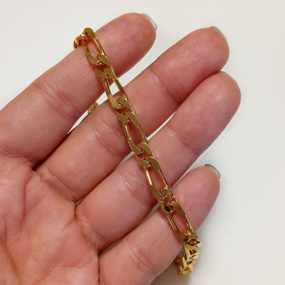 Gold tone Figaro chain bracelet, 7 1/2 inches: Gold tone Figaro chain bracelet, 7 1/2 inches. Length 7 1/2 inches. Width 1/4 inches. Condition very good.
