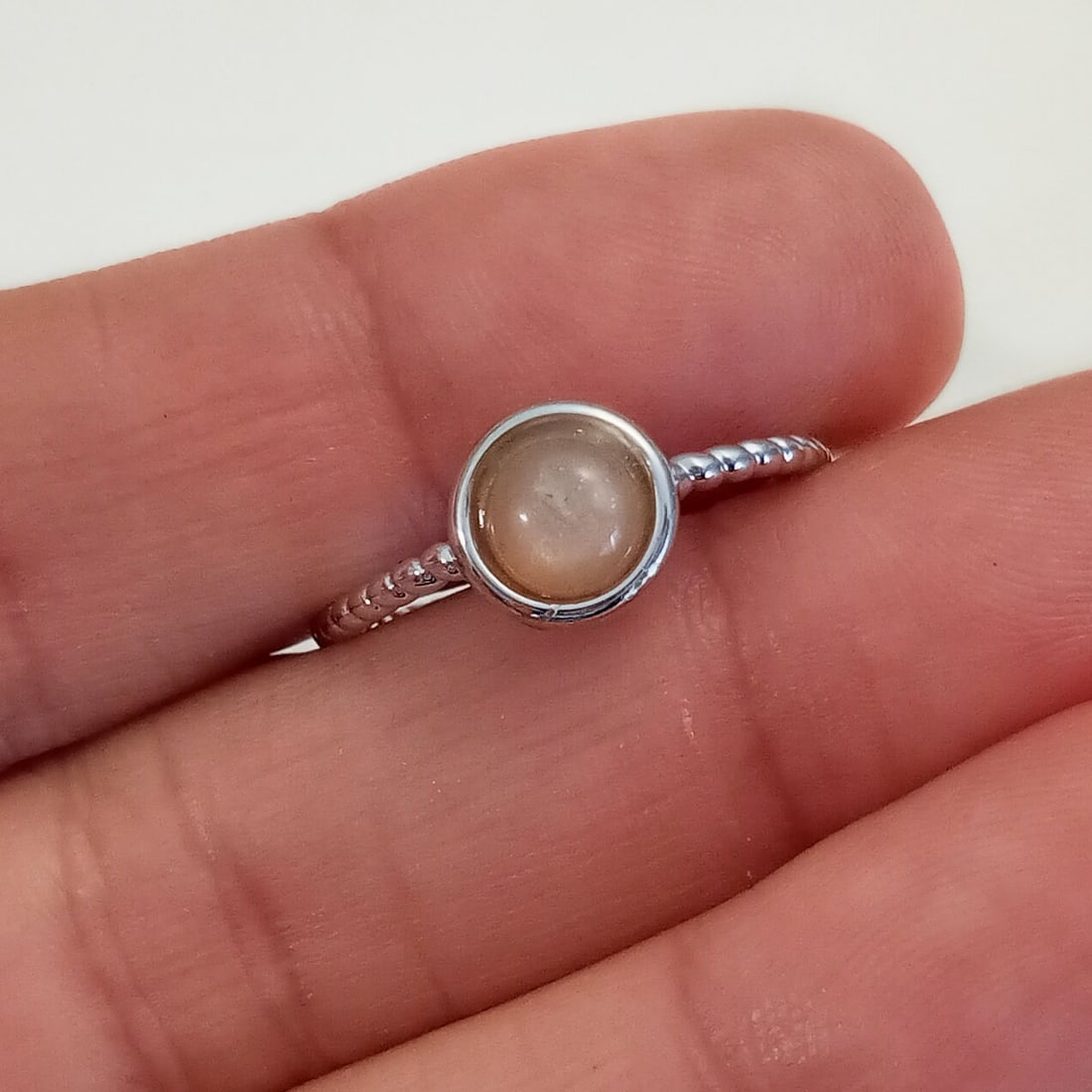 Silver tone pink faux moonstone cab open ring sz 7-11: Silver tone round shape pink faux moonstone cab textured finish open ring, adjustable size approximately from 7 to 11. Top measured 5/16 inches in diameter. Condition very good.