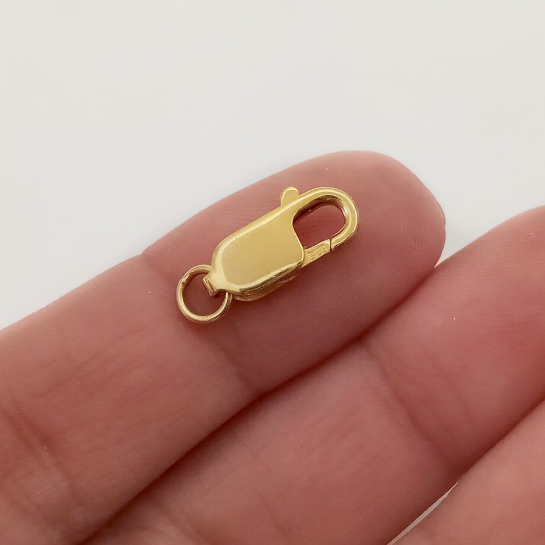 14K Yellow gold lobster clasp: 14K Yellow gold lobster clasp for bracelet, chain or necklace. Weight 1.0 gram. Length 14 mm without the loop. Hallmarked 585. Condition very good.