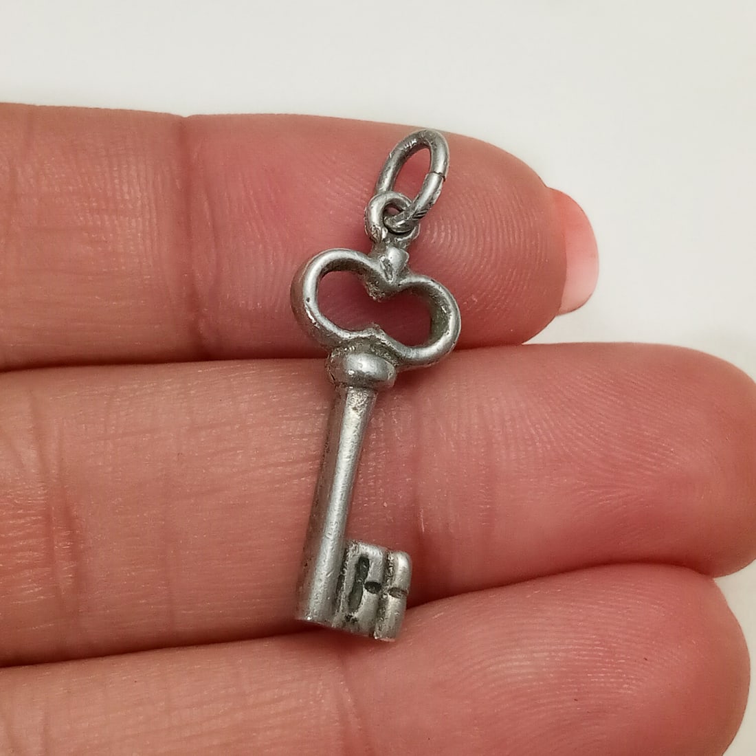 Vintage sterling silver Key charm: Vintage sterling silver Key charm. Weight 1.94 grams. Length 1 1/8 inches with bail. No hallmark, tested 925 sterling silver. Condition very good.