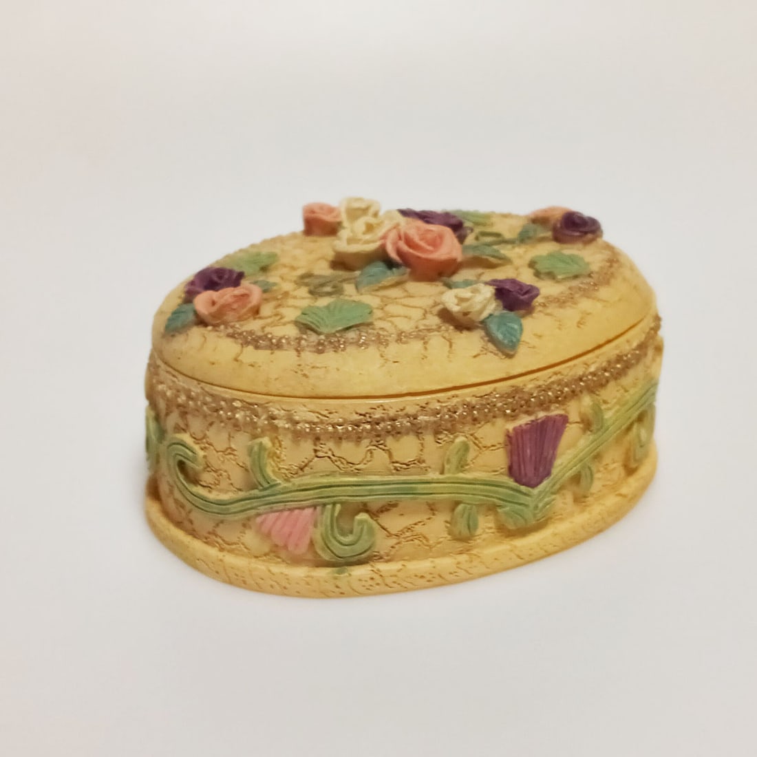 Vintage textured Rose Flower oval trinket jewelry box: Vintage textured finish molded look Rose Flowers Vines Leaves yellow tan oval shape trinket jewelry box with lid. Measured 3 1/2 x 2 3/4 x 1 1/2 inches. Stle #7024. Ceramic World Inc. Material polyres