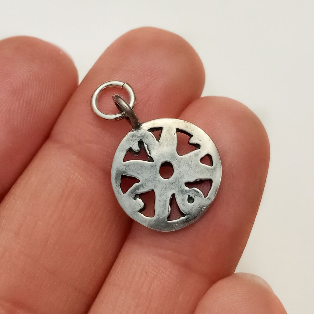 Vintage sterling silver Flower round charm pendant: Vintage sterling silver Flower round charm pendant. Weight 1.05 grams. Length 7/8 inches with bail. Hallmarked 925. Condition very good.