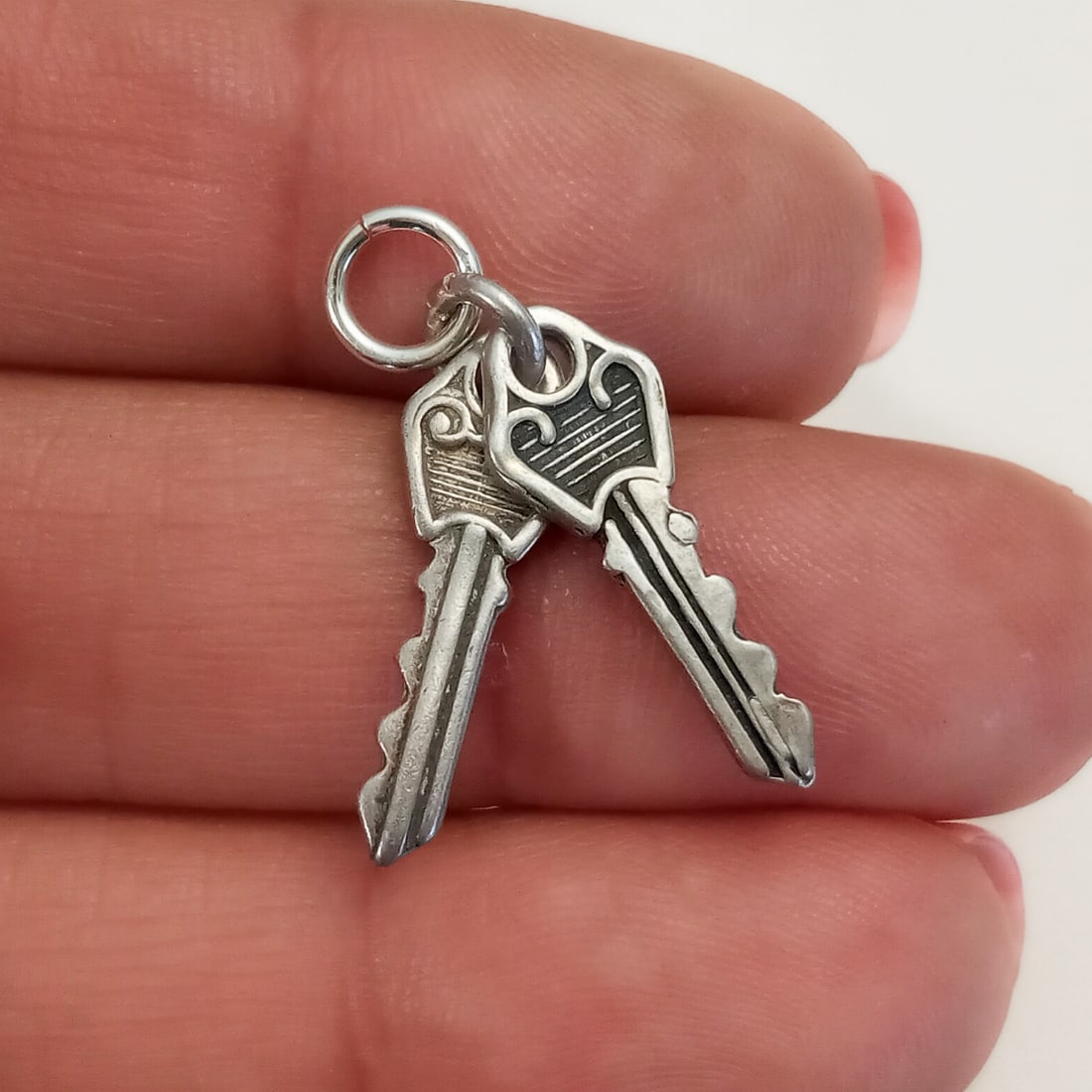 Vintage sterling silver Pair of Keys charm: Vintage sterling silver Pair of Keys charm pendant. Weight 1.89 grams. Length 1 inch with bails. Hallmarked Sterling. Condition very good.