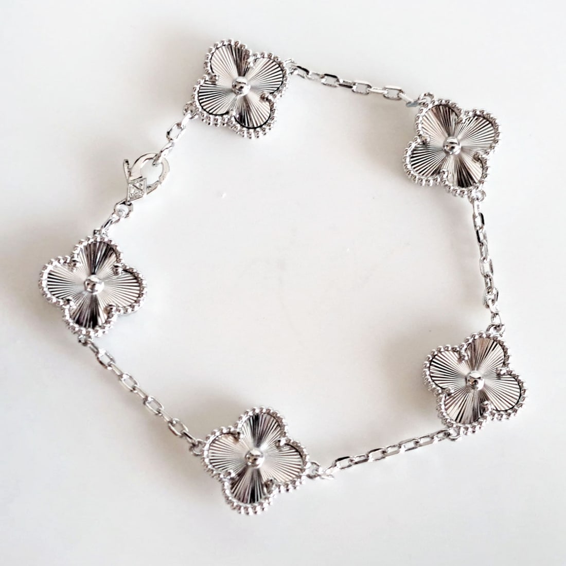 White gold tone 4 leaves diamond cut finish flowers bracelet, 7.5": White gold tone 4 leaves diamond cut finish flowers bracelet with fancy clasp. Same flowers finish from both sides. Weight 13.7 grams. Length 7.5". Condition excellent.