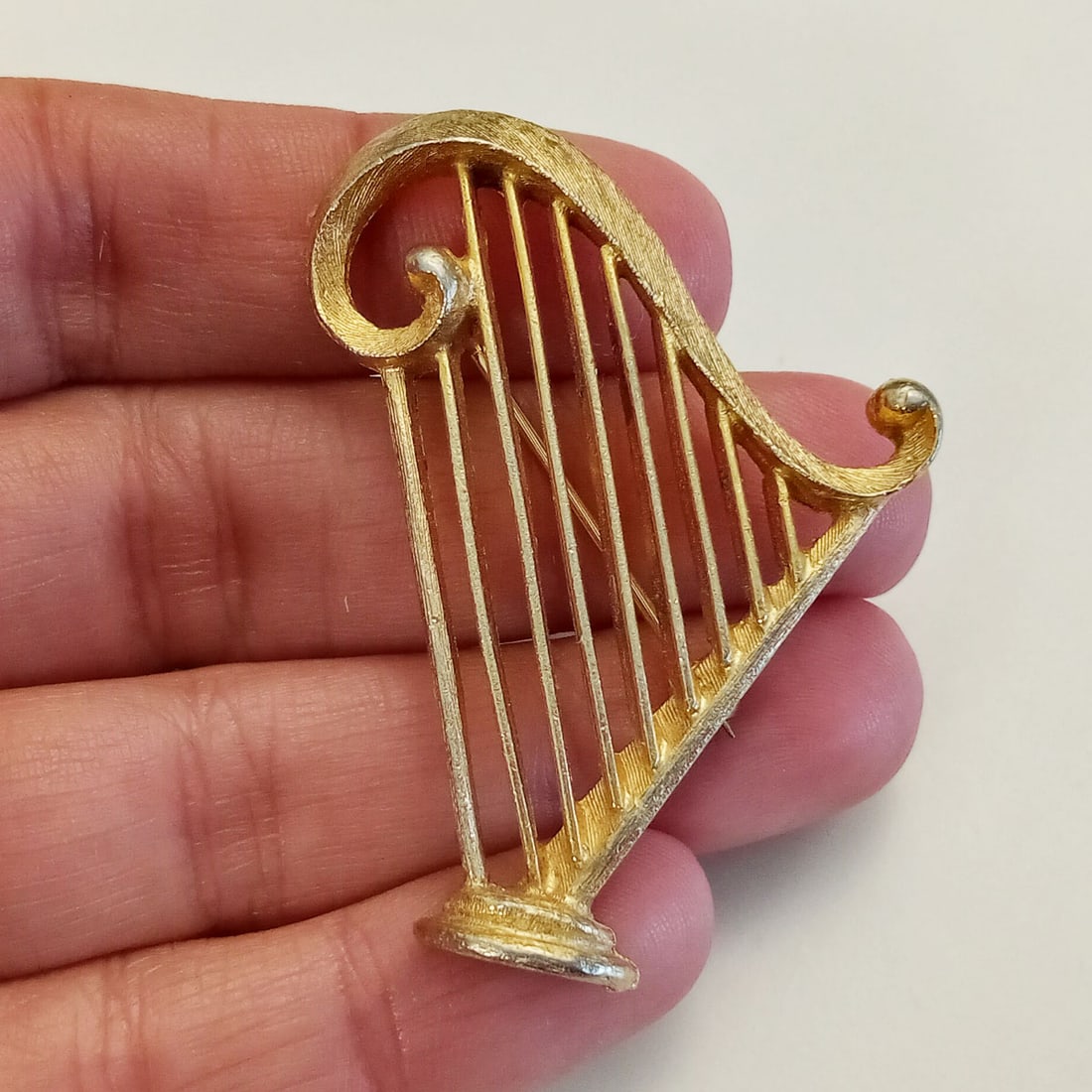 TARA Vintage gold tone textured finish Harp brooch: TARA Vintage gold tone textured finish Harp brooch, signed. Measured 2 x 1 1/4 inches. Hallmarked Tara, trademark symbol. Condition very good.