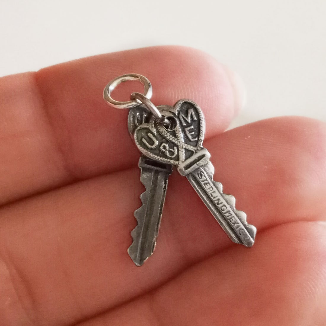 Vintage sterling silver U & ME pair of keys charm: Vintage oxidized sterling silver U & ME pair of keys charm pendant. Weight 1.86 grams. Length 1 inch with bail. Hallmarked Sterling Mexico. Condition very good.